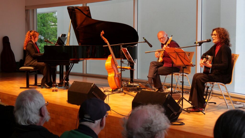 Auf dem Bild ist Turiner Trio „La Desbandá“ bei seinem Auftritt zum 80. Jahrestag der Befreiung vom Faschismus im Stadthaus Ulm zu sehen. Das Trio besteht, wie auf dem Bild zu sehen aus Tiziana Cappellino am Flügel, López Massimo Sartori mit einer E-Guitarre und der Gitarristin und Sängerin Angeles Agyado. Es sang Lieder des Widerstands gegen das Franco-Regimes, die Nazidiktatur sowie antifaschistische und Antikriegslieder. Foto: Konrad Sedding